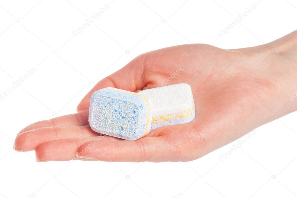 Female hand holding dishwasher tablets on white background