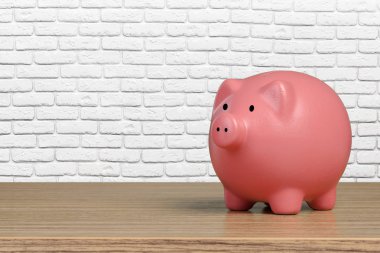 Ahşap masa üzerinde pembe kumbara