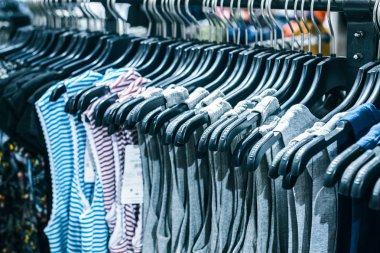 Askılarda farklı giysiler. Kapatın.