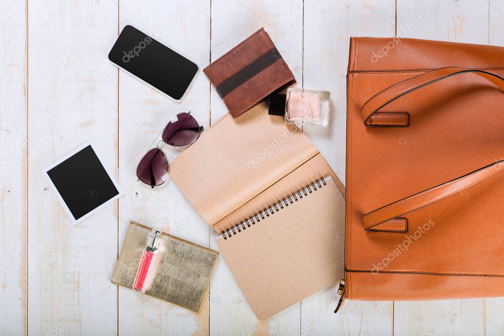 View on women bag stuff on wooden background 