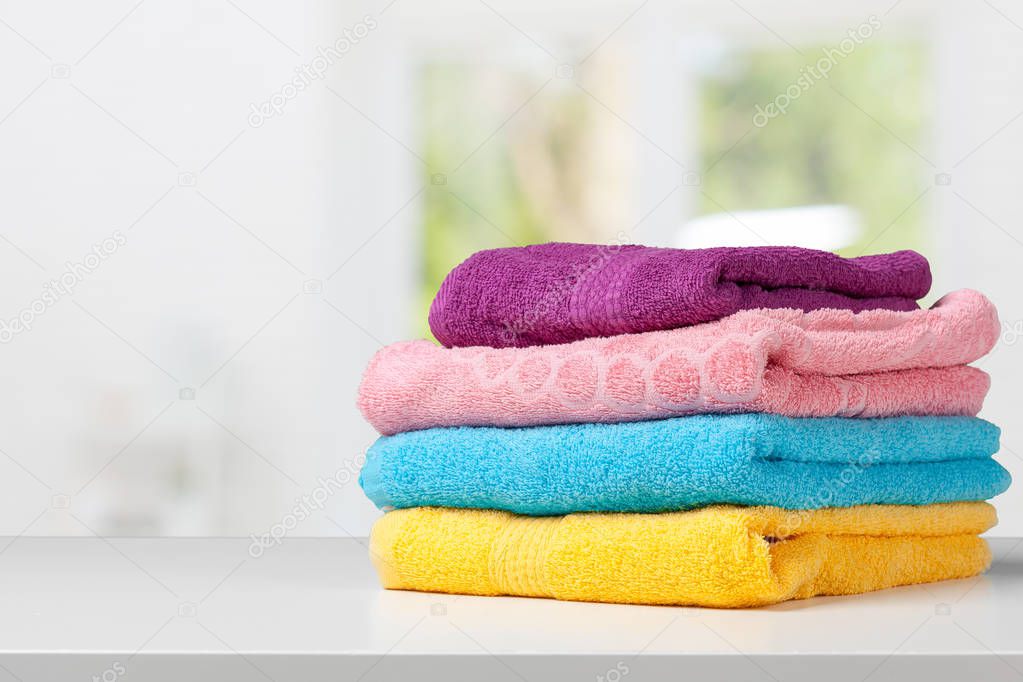 Stack of bath towels on light white background closeup