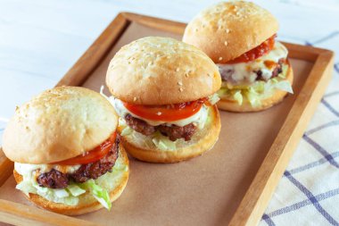 Sulu sığır eti burgers ahşap masa, yakın çekim kesme