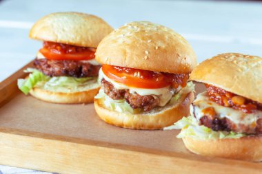 Sulu sığır eti burgers ahşap masa, yakın çekim kesme