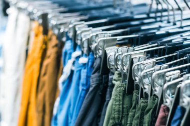 Askılarda farklı giysiler. Kapatın.