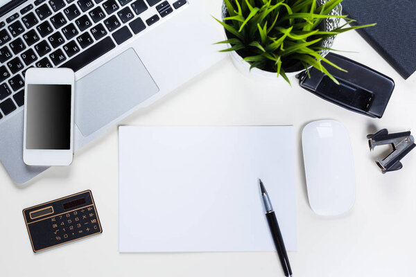 Белый стол с кучей вещей на нем. Вид сверху
