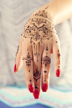 Kırmızı manikürlü Mehndi tasarım, eliyle yakın çekim