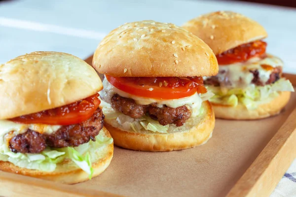 Sulu sığır eti burgers ahşap masa, yakın çekim kesme