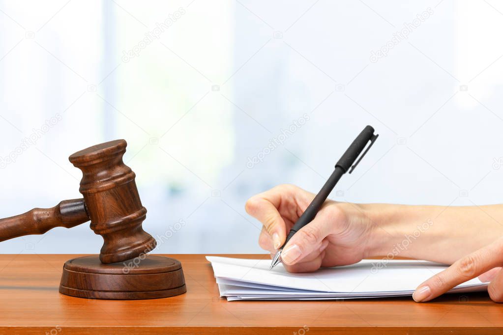 Judge Writing On Paper In Courtroom