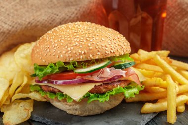 Hamburger patates kızartması ve cips kayrak tabakta ile yakın çekim    