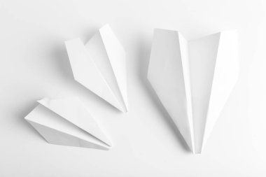 Düz beyaz kağıt uçak beyaz renk arka plan üzerinde yatıyordu