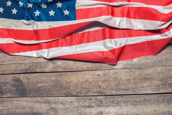 An American Flag Lying on an aged, weathered rustic wooden background