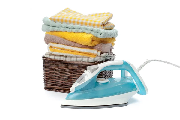 Electric iron and pile of clothes isolated on white background