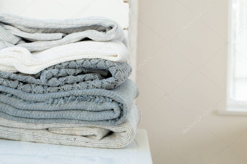 Stack of white cozy knitted sweaters 