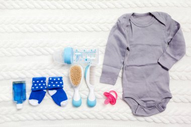 Giyim ve öğeleri kümesi üzerinde açık renkli bir bebek için 