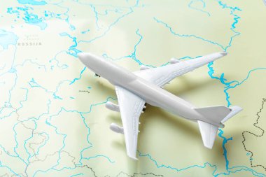 minyatür bir harita üzerinde uçan bir yolcu uçağı