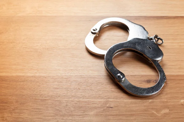 Handcuffs Wooden Table Close View — Stock Photo, Image