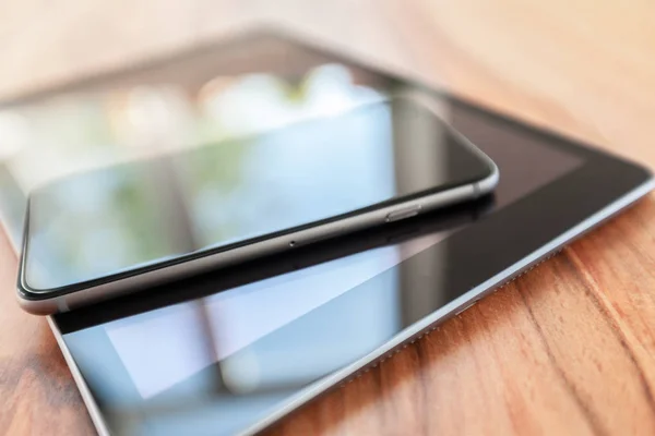 digital tablet and smart phone on wooden table