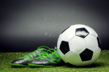 futbol topu ve ayakkabısı futbol sahası üzerinde