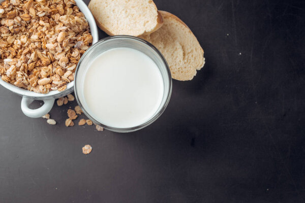 Muesli breakfast with milk on black background