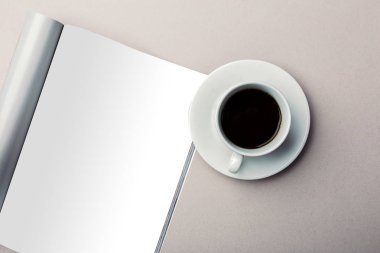 Dergi sayfaları ve kahve fincan tabağı üzerinde