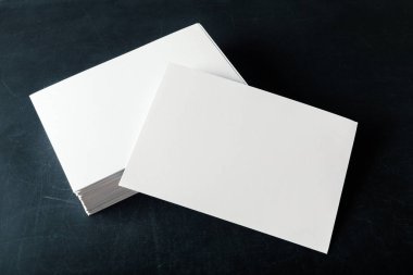 Kağıt boş kartvizit koyu arka plan üzerinde desteklenen yakın çekim 