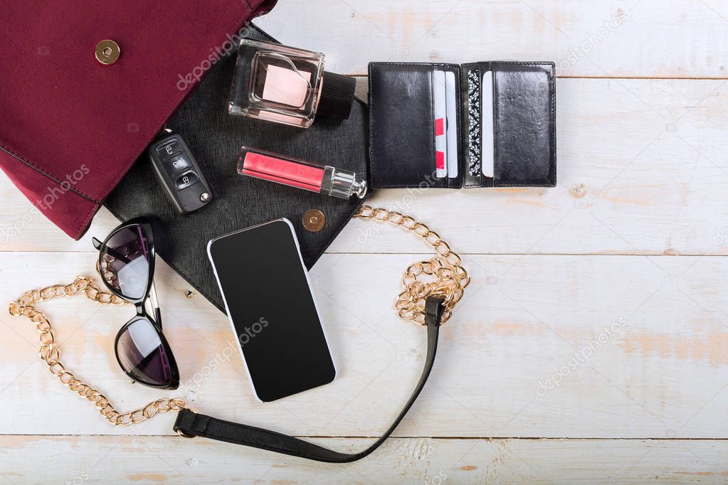 female bag stuff on wooden background, close-up 