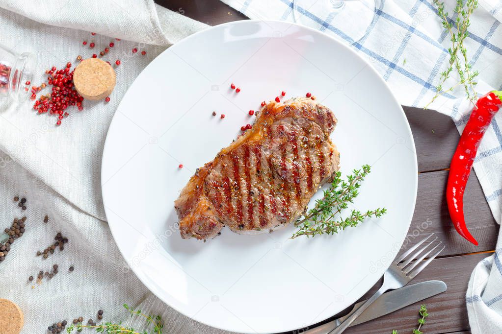 Grilled steak with spices on white plate