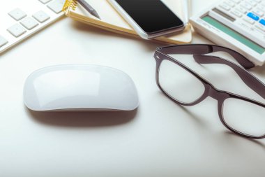 Ofis resepsiyon masası bilgisayar klavye, malzemeleri, hesap makinesi, kalem, gözlük ile 