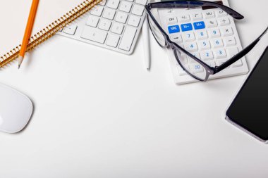 Ofis resepsiyon masası bilgisayar klavye, malzemeleri, hesap makinesi, kalem, gözlük ile 