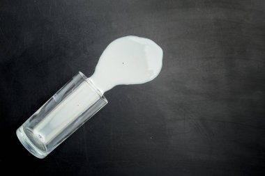 Dökülen süt koyu arka plan, üstten görünüm