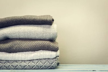 Ahşap arka plan üzerinde kazak örme rahat yığını yakın çekim 