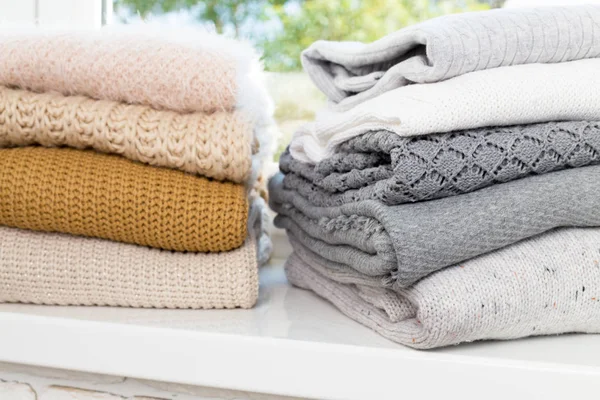 Beyaz masada kazak örme yığını beyaz sıcak yakın çekim 