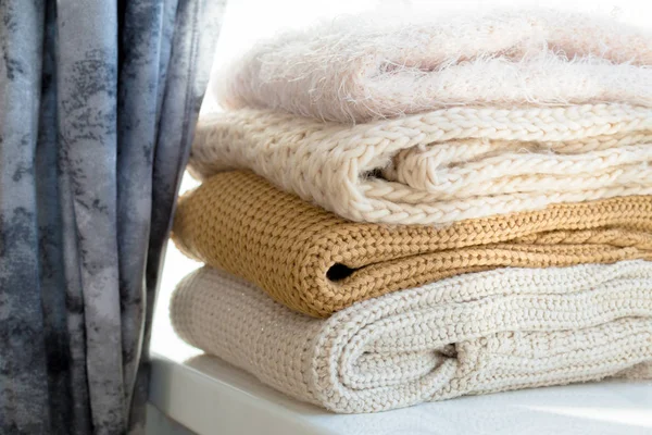 Beyaz masada kazak örme yığını beyaz sıcak yakın çekim 