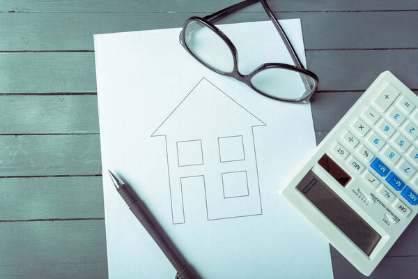 Концепция ипотеки или кредита. Рисунок дома и калькулятор
