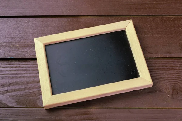 Küçük ahşap çerçeveli boş yazı tahtası üstten görünüm 