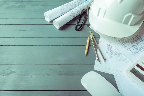 Top view of architectural plans on wooden desk