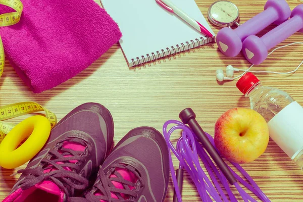 Training shoes and sports equipment on wooden floor