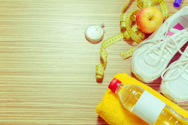 Training shoes and sports equipment on wooden floor