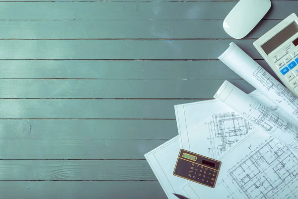 Top view of architectural plans on wooden desk