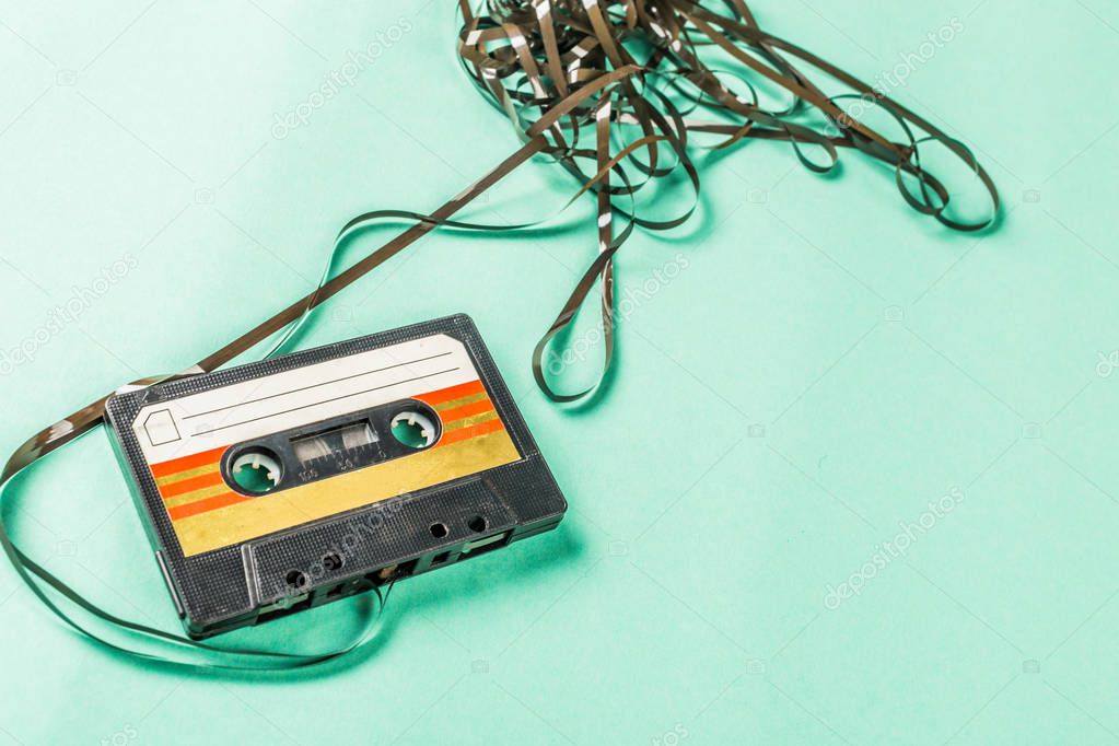 Old audio cassette on turquoise background