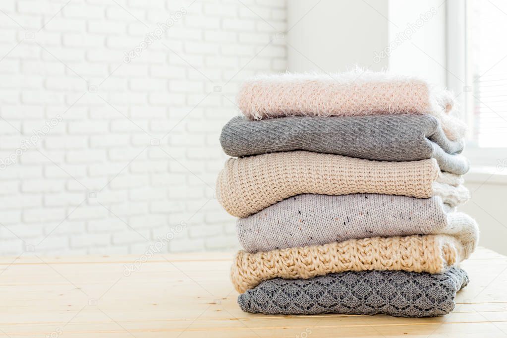 Stack of white cozy knitted sweaters 