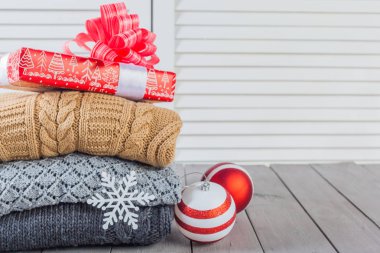 Ahşap bir masa üzerinde kazak örme yığını beyaz rahat