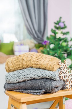 Ahşap bir masa üzerinde kazak örme yığını beyaz rahat