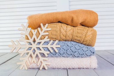 Ahşap bir masa üzerinde kazak örme yığını beyaz rahat