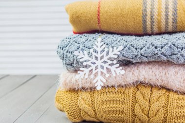 Ahşap bir masa üzerinde kazak örme yığını beyaz rahat