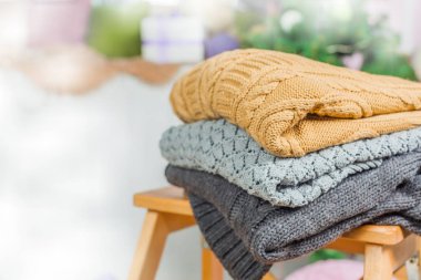 Ahşap bir masa üzerinde kazak örme yığını beyaz rahat