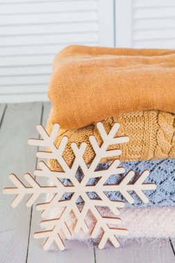 Ahşap bir masa üzerinde kazak örme yığını beyaz rahat