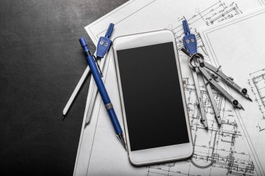 İnşaat çizimleri ve smartphone üzerinde siyah arka plan planlama