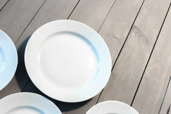 木製のテーブルに空の白い皿の立面図 — ストック写真