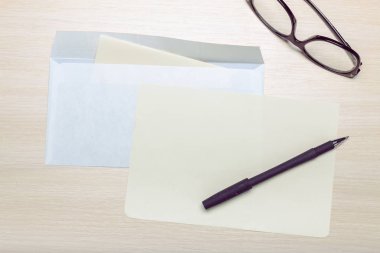 Boş zarf, gözlük ve ahşap zemin üzerine kalem fotoğrafı